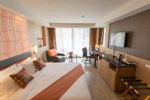 een hotelkamer met een groot bed en een bureau bij Dynasty Grande Hotel in Bangkok