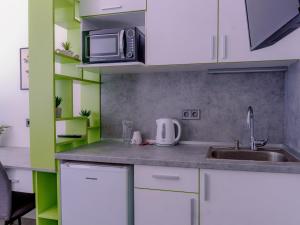 una cucina con lavello e microonde di DORM BG pet-friendly Aparthotel a Stara Zagora