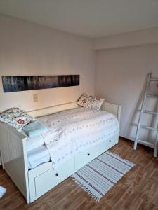a bedroom with a white bed and a ladder at Haus Dany in Raeren