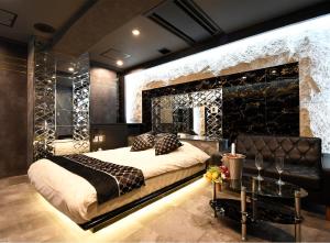 東京にあるHotel Gran Villaの石壁のベッドルーム1室(大型ベッド1台付)