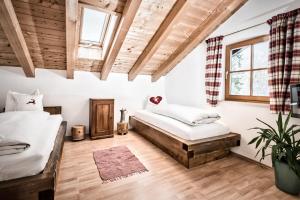 two beds in a room with wooden ceilings at Haus Miele in Garmisch-Partenkirchen