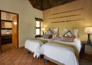 Madikwe River Lodge by Dream Resorts في محميّة ماديكوي الطبيعيّة للطرائد: غرفة نوم بسريرين في غرفة