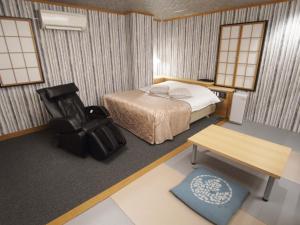 una camera con letto, scrivania e sedia di ホテルラパンセ Adult Only a Saitama