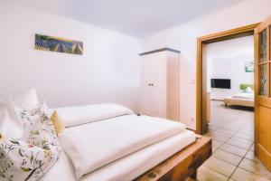 a bedroom with a bed with white sheets and a mirror at Haus Miele in Garmisch-Partenkirchen