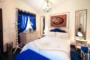 a bedroom with a blue and white bed and a mirror at Casa Nostra Boutique Hotel in Paraty