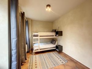 a small room with a bunk bed and a rug at Au regard des biches 