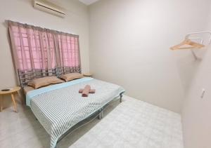 Air-home No 9 Kampung Boyan, 4BR, 9pax, Netflix في تايبينغ: غرفة نوم صغيرة مع سرير ونافذة وردية