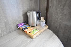 a coffee maker sitting on a wooden tray on a table at Havenzicht in Dinteloord