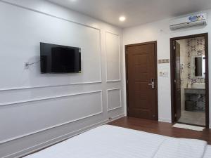 a room with a tv on the wall and a door at Minh Khue Hotel in Vĩnh Long