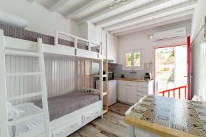 a bedroom with two bunk beds and a kitchen at Elenitas Town house with Balcony and Sea View in Mýkonos City