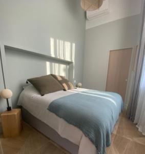 ナントにあるLa Suite de l'Abbaye - climatisation et petit dejのベッドルーム1室(青い毛布付きのベッド1台付)