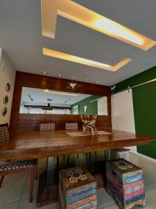 un grande tavolo in legno in una stanza con parete verde di Casa Ferradura com hidro,piscina e 500 metros da praia a Búzios