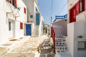 a narrow alley with blue doors and white buildings at Elenitas Town house with Balcony and Sea View in Mikonos
