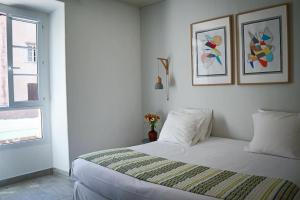 博尼法喬的住宿－Le Royal Hôtel Restaurant，卧室配有一张墙上有两张照片的床。