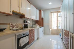 una cocina con electrodomésticos blancos y armarios de madera en Carreteria 73 Malaga Center, en Málaga