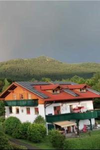 um edifício com telhados vermelhos com uma montanha ao fundo em Ferienwohnung HOAMAT Schmalzreich Andrea em Lam