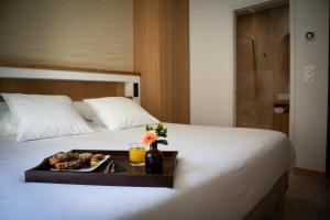 un vassoio di cibo su un letto in una camera d'albergo di Le Royal Hôtel Restaurant a Bonifacio