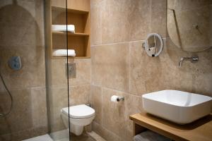 La salle de bains est pourvue d'un lavabo, de toilettes et d'une douche. dans l'établissement Le Royal Hôtel Restaurant, à Bonifacio