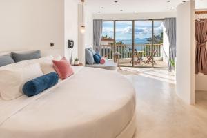 ein weißes Bett in einem Zimmer mit Meerblick in der Unterkunft Ampersand Resort in Bophut 