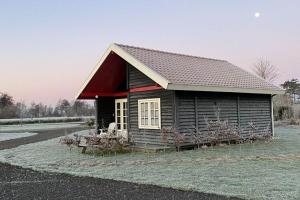 a small wooden cabin with a red roof at Chalet in Friesland near Alde Feanen in De Veenhoop