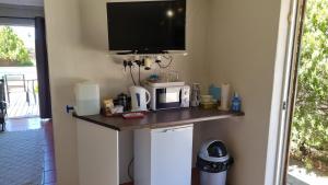 eine Küche mit einer Theke mit einer Mikrowelle und einem TV in der Unterkunft Spandau Manor in Graaff-Reinet