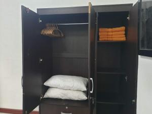 un placard noir avec une pile de serviettes pliées dans l'établissement Stargazers Apartment, à Olongapo