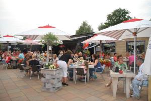 a group of people sitting at tables at a restaurant at Vakantiepark Schouwen in Renesse