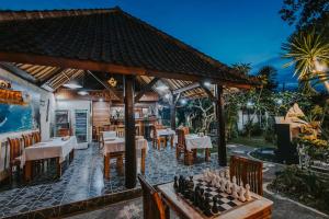 un restaurant avec un échiquier sur une terrasse dans l'établissement Alam Nusa Bungalow Huts & Spa, à Nusa Lembongan