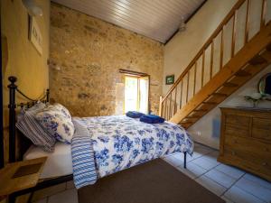 a bedroom with a bed in a room with a staircase at Le Nid de Faucons in Lalinde