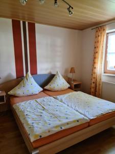 a bedroom with a large bed with pillows on it at Ferienwohnung HOAMAT Schmalzreich Andrea in Lam