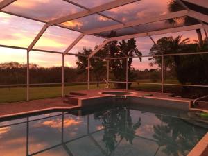 una piscina con patio e tramonto di Villa Susanne a Lehigh Acres
