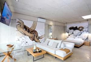 sala de estar con sofá blanco y mural en Marnos Luxury Villas en Kamilari
