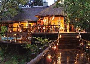 una casa con una escalera que conduce a ella con luces en Madikwe River Lodge by Dream Resorts, en Reserva de Madikwe
