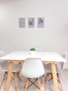 una mesa de comedor blanca con sillas blancas en BORGES HOUSE APARTS Apartamentos a dos cuadras del obelisco! en Buenos Aires