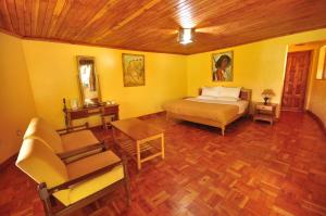een slaapkamer met een bed, een stoel en een tafel bij Naiberi River Campsite & Resort in Eldoret