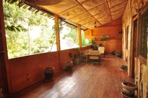 Naiberi River Campsite & Resort في إلدوريت: شرفة منزل خشبي مع طاولة وكراسي