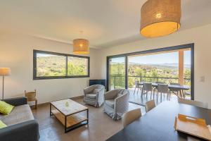 a living room with a couch and a table at Les Villas de Lorello in Porticcio