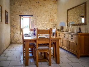 a dining room with a wooden table and chairs at Le Nid de Faucons in Lalinde