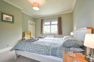 a bedroom with a bed and a table and a window at Rose Cottage Elsdon in Elsdon