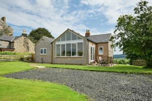 a home with a large window on the side of it at Rose Cottage Elsdon in Elsdon