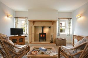 a living room with a fireplace and a tv at The Lodge Elsdon in Elsdon