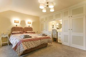 a bedroom with a bed and a dresser and a mirror at The Lodge Elsdon in Elsdon
