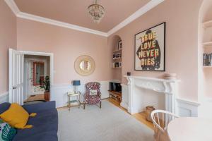 a living room with a blue couch and a fireplace at Stylish Central Apartment with Parking - Garden and Workspace in Bath