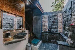 y baño con lavabo y bañera. en Alam Nusa Bungalow Huts & Spa, en Nusa Lembongan