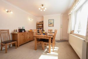 uma sala de jantar com uma mesa de madeira e cadeiras em Seaview Cottage Amble em Amble