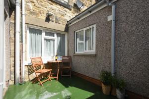 a patio with a table and chairs and a window at Seaview Cottage Amble in Amble