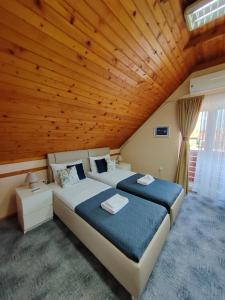 1 dormitorio con 2 camas y techo de madera en Sole Mio Kula en Kula