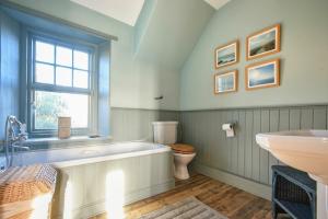 a bathroom with a tub and a toilet and a sink at Whistlewood in Bamburgh