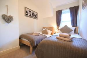 a bedroom with two beds and a heart hanging on the wall at Whistlewood in Bamburgh