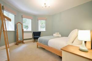 a bedroom with a bed and a desk with a lamp at The Lodge Alnwick in Alnwick